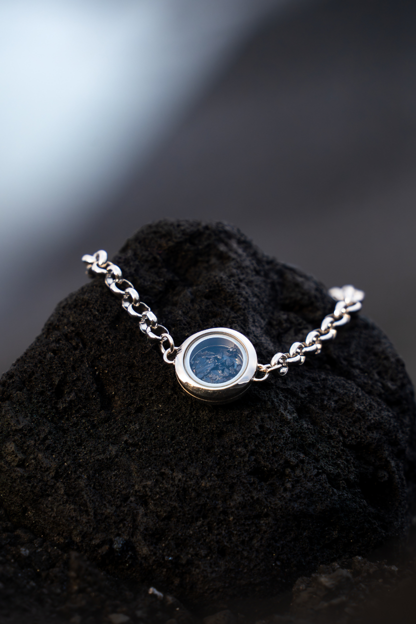 Dragon Glass bracelet on a stone on a black textured surface