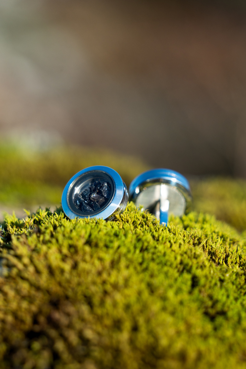 Dragon Glass Cufflinks from Lava Show on a piece of green moss with a blurred natural background.