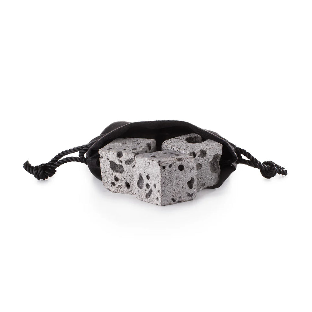 Three grey lava Whiskey stones in a  black drawstring bag on a white background