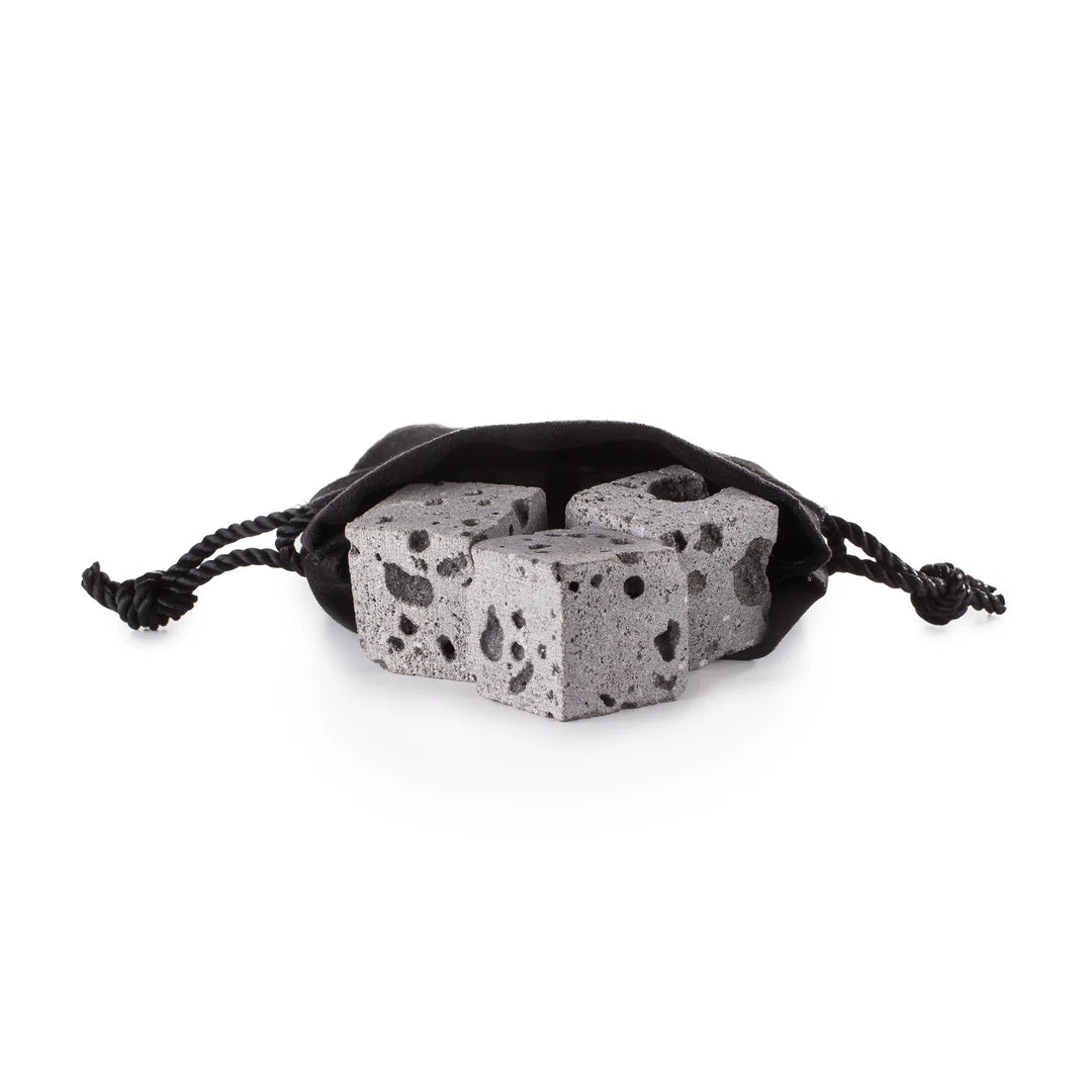 Three grey lava Whiskey stones in a  black drawstring bag on a white background
