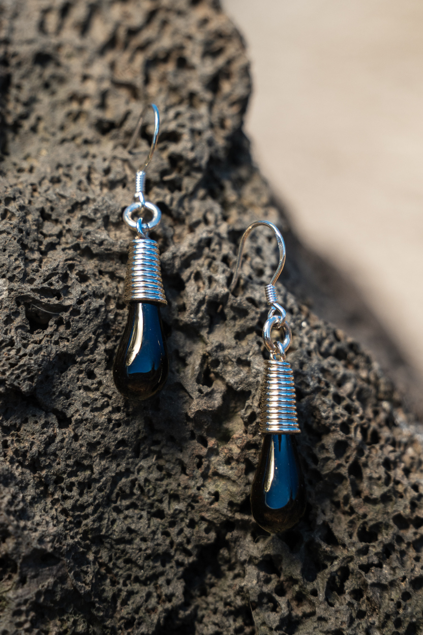  Pele’s Tear – sterling silver earrings  from Lava Show on a textured stone surface